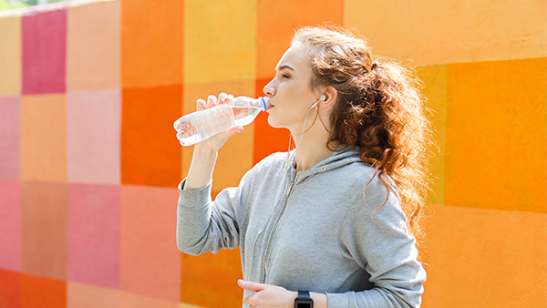 Young woman drinking bottle of water